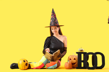 Sticker - Young woman dressed for Halloween as witch with pumpkins on yellow background