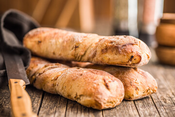 Canvas Print - Crusty rustic baguette on wooden table.