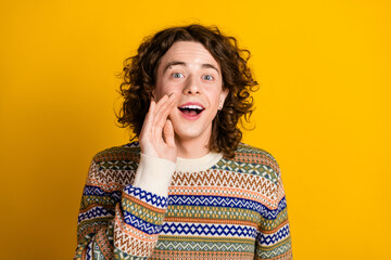 Poster - Photo of positive guy with wavy hairdo dressed ornament sweater announcing sale hold palm on cheek isolated on yellow color background