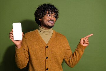 Sticker - Photo of attractive young man hold device white screen look point empty space dressed brown clothes isolated on khaki color background