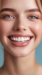 © Maria Mikhaylichenko - Radiant smile illuminates a close-up portrait, showcasing flawless skin, piercing blue eyes, and perfectly aligned white teeth against a soft blue background.