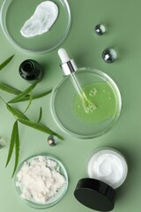 Wall Mural - Petri dishes with cosmetic products, pipette and leaves on green background, flat lay