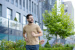 © Tetiana - Smiling young man running on the streets of the city, doing a morning jog and doing sports