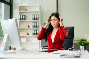 Overworked young Asian businesswoman office worker suffering from neck pain after had a long day