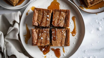 A plate of brownies with caramel drizzled on top