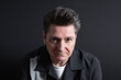 © Beti Argi - Close-up portrait of a very serious and sad 50-year-old man looking at camera. Dark background. Copy space. Concept of sadness, depression and mental health