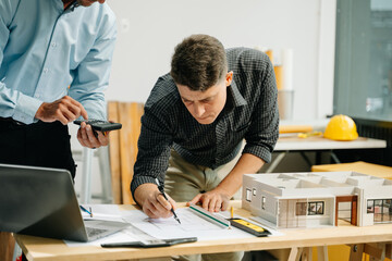 two colleagues discussing data working and tablet, laptop with architectural project at construction