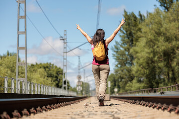 Young woman enjoying nature.Hiking in the mountains, observing the landscape.Doing sports and physical activity.Let's take care of our natural surroundings and our environment.Moments of disconnection