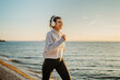 © Dusan - Young caucasian woman running or jogging on the beach at sunset