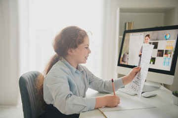 Canvas Print - Photo of clever smart girl schoolkid learner sitting chair desk studying from home doing homework read test daylight indoors