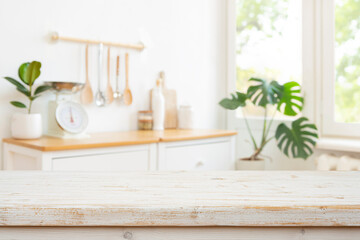 Wall Mural - kitchen table top on blur pastel colored kitchenware, furniture and interior background