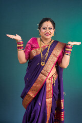 Cheerful Indian traditional woman presenting something, showing copy space on her palm