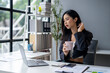 © apichat - A woman in a business suit is sitting at a desk with a laptop