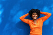 © VISTA by Westend61 - Cheerful woman with hands in head near blue wall