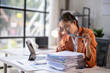 © Wasana - Asian accountant woman having headache after working with financial documents