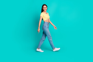 Sticker - Full body profile portrait of pretty young woman walk empty space wear top isolated on turquoise color background