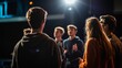 © Korawan - A group of people are standing in a dark room with a spotlight on them