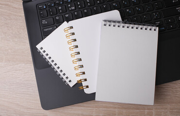 Laptop and white blank spiral notebooks on table. Education, business concept. Top view