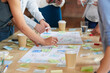© Moose Coop/peopleimages.com - Hands, group and documents in office with sticky note, planning and mindmap for inspiration at company. People, huddle and scrum for brainstorming, teamwork or synergy for solution at creative agency