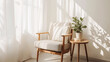 © Vian - Simple, inviting reading nook with a neutral-colored armchair, a wooden side table, and a small potted plant. Clean lines and soft natural lighting