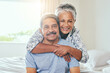 © peopleimages.com - Portrait, bedroom and old couple with smile, hug and bonding together with anniversary, care and home. Face, senior man and mature woman with embrace, marriage and relationship with love and holiday