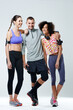 © peopleimages.com - Happy, group and people with fitness in studio for training, teamwork and support in workout. Athlete, smile and friends with confidence by white background for gym, exercise and sports together