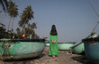 © Milou Dirks - round traditional fishing boats on the shore in Vietnam with model standing between them in green dress