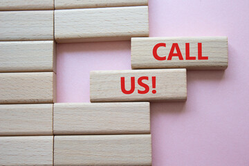 Call Us symbol. Wooden blocks with words Call Us. Beautiful pink background. Business and Call Us concept. Copy space.