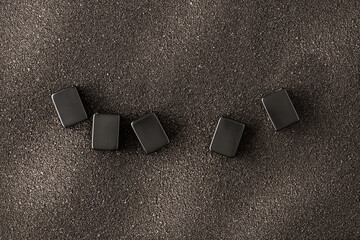 five empty rectangles on black sand, place for text, letters, word. tiles or black dices on a black 