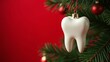 © Ekaterina - White tooth hanging on Christmas tree on a red background. Free space for text. Christmas medical background, card, banner