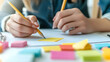 © Neungruedee - Person Writing on Paper with Colorful Sticky Notes
