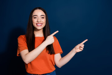 Wall Mural - Photo of adorable gorgeous woman wear stylish orange clothes introduce empty space isolated on dark blue color background