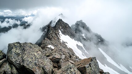 Wall Mural - A panoramic view of a mountain peak with clouds surrounding it.