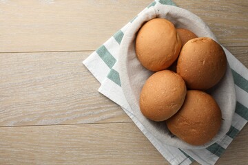 Wall Mural - Fresh tasty buns on wooden table, top view. Space for text