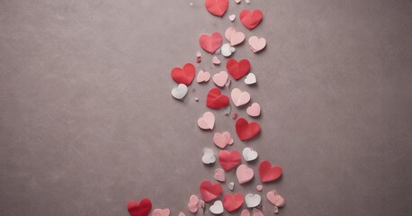 Poster - A collection of red and pink paper hearts scattered across a gray background