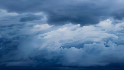 Wall Mural - Dark, ominous storm clouds are gathering in the sky, creating a dramatic and foreboding atmosphere. The clouds are swirling and churning, hinting at the powerful forces of nature at play
