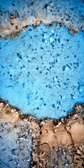 Poster - Aerial view rocky surface with patches of blue and brown, possibly indicating a water source or a geological formation