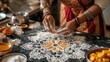 © keetazalay - A woman preparing Diwali sweets at home, with a mandala made of flour and spices drawn on the kitchen counter