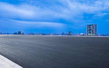 Wall Mural - Empty asphalt road and cityscape with skyline in modern city at night