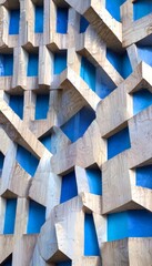 Aufkleber - a close-up view building facade with a geometric pattern of blue and gray concrete blocks arranged in a complex, overlapping manner