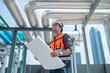 © Washburn - Engineer Inspecting Industrial Pipes on Rooftop