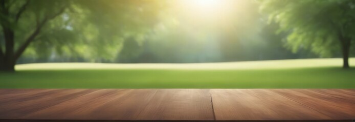 Poster - A wooden table sits in the foreground, with a blurred park scene in the background featuring trees and a grassy field bathed in sunlight