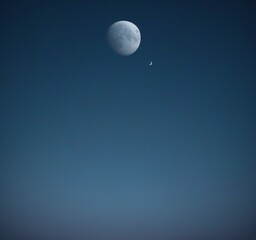 Poster - A full moon and a crescent moon are visible in the night sky, with the crescent moon positioned slightly higher than the full moon