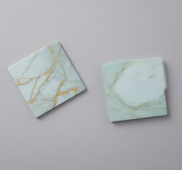 Leinwandbilder - Two square coasters with marble patterns in light blue and light green are placed against a gray background.