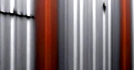 Aufkleber - a blurred metal surface with vertical lines and a small hole, creating a sense of motion and depth