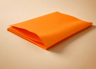 Aufkleber - A folded orange paper is placed on a light beige surface