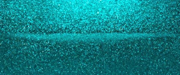 Aufkleber - A close-up view of a textured surface with a shimmering, turquoise-colored glitter effect.