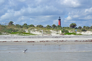 Ponce Inlet, Beach, Florida, Lighthouse, dunes, ocean and cloudy sky landscape. 