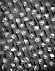Leinwandbilder - a close-up view of numerous faceted diamonds arranged in a grid-like pattern, with a black and white color scheme.