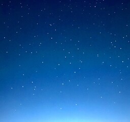 A starry night sky with numerous small white stars scattered across a deep blue background.